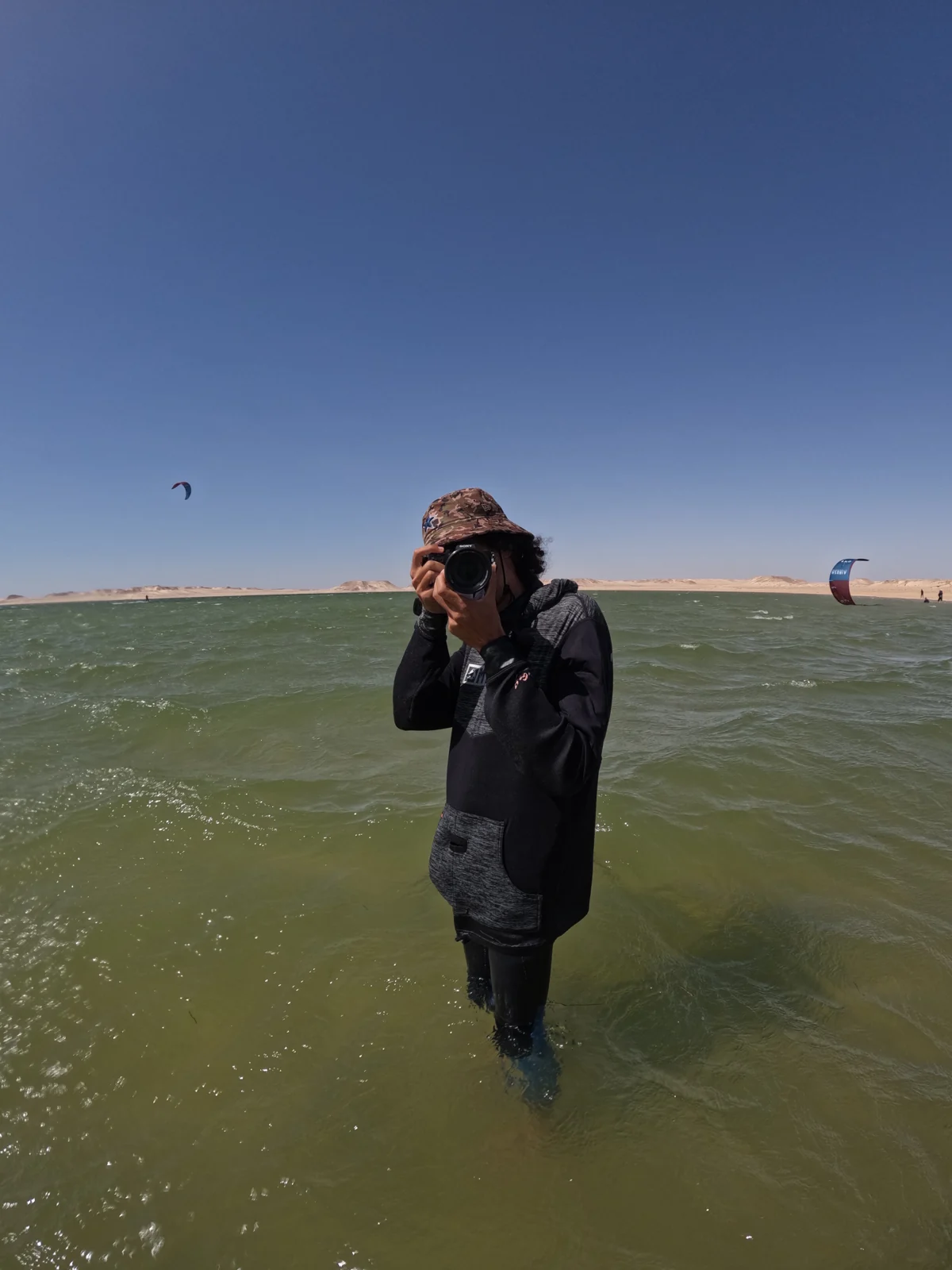 Photographer with a camera standing in shallow water