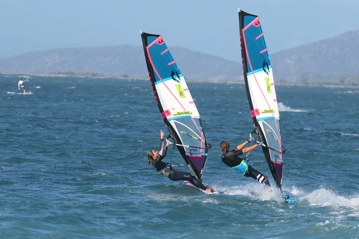 Two windsurfers planing side by side